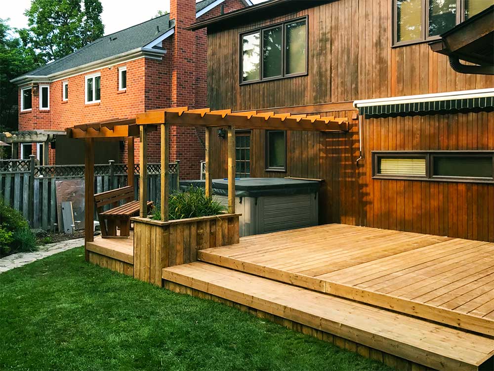 Custom Yard Worx back-yard deck oasis with railing and seating