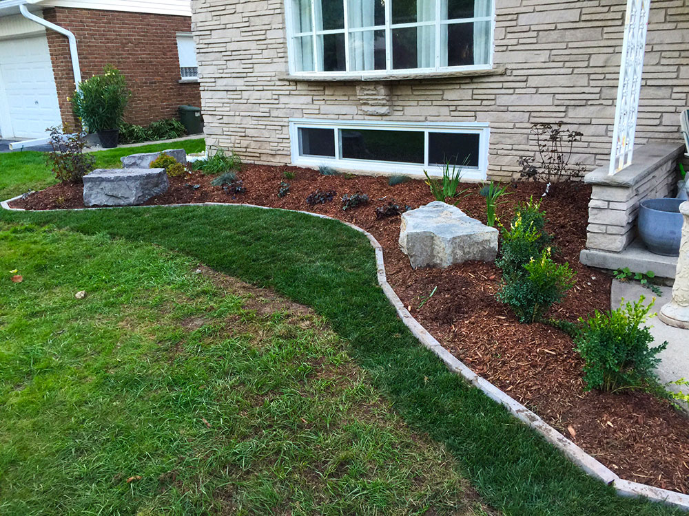 Hand-laid mulch in a front garden bed by Yard Worx