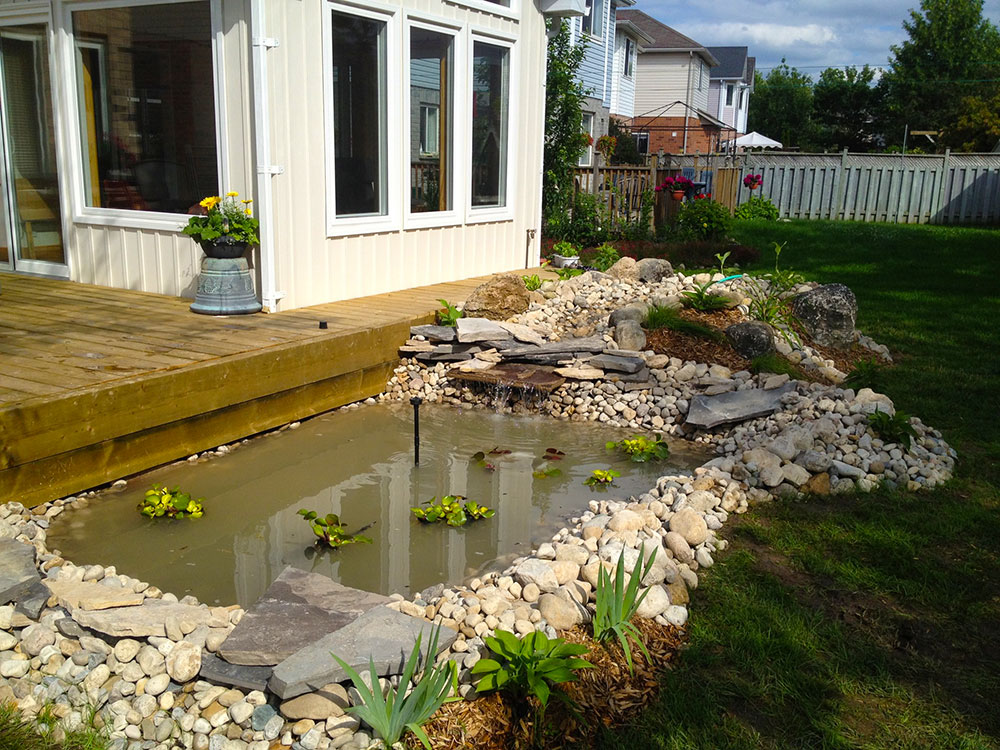 Interlock surround on a backyard stone pond build